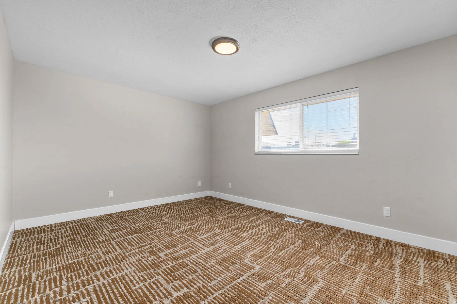 Unfurnished room with light colored carpet and baseboards