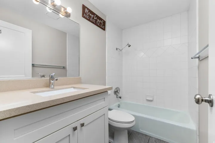 Full bath featuring vanity, bathing tub / shower combination, and tile patterned flooring