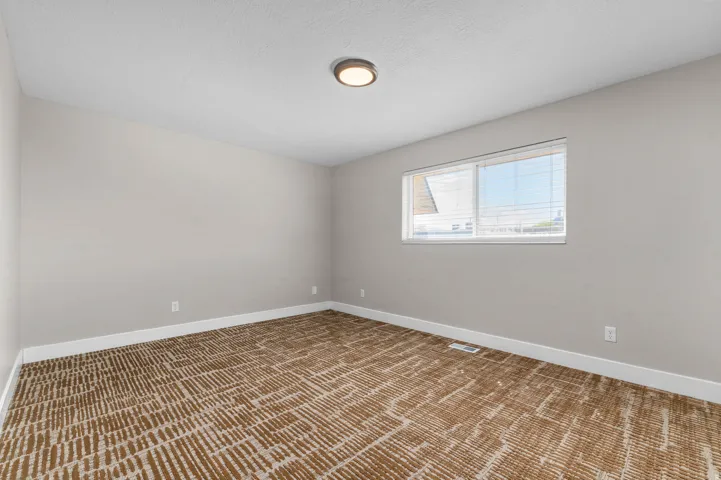 Unfurnished room with light colored carpet and baseboards