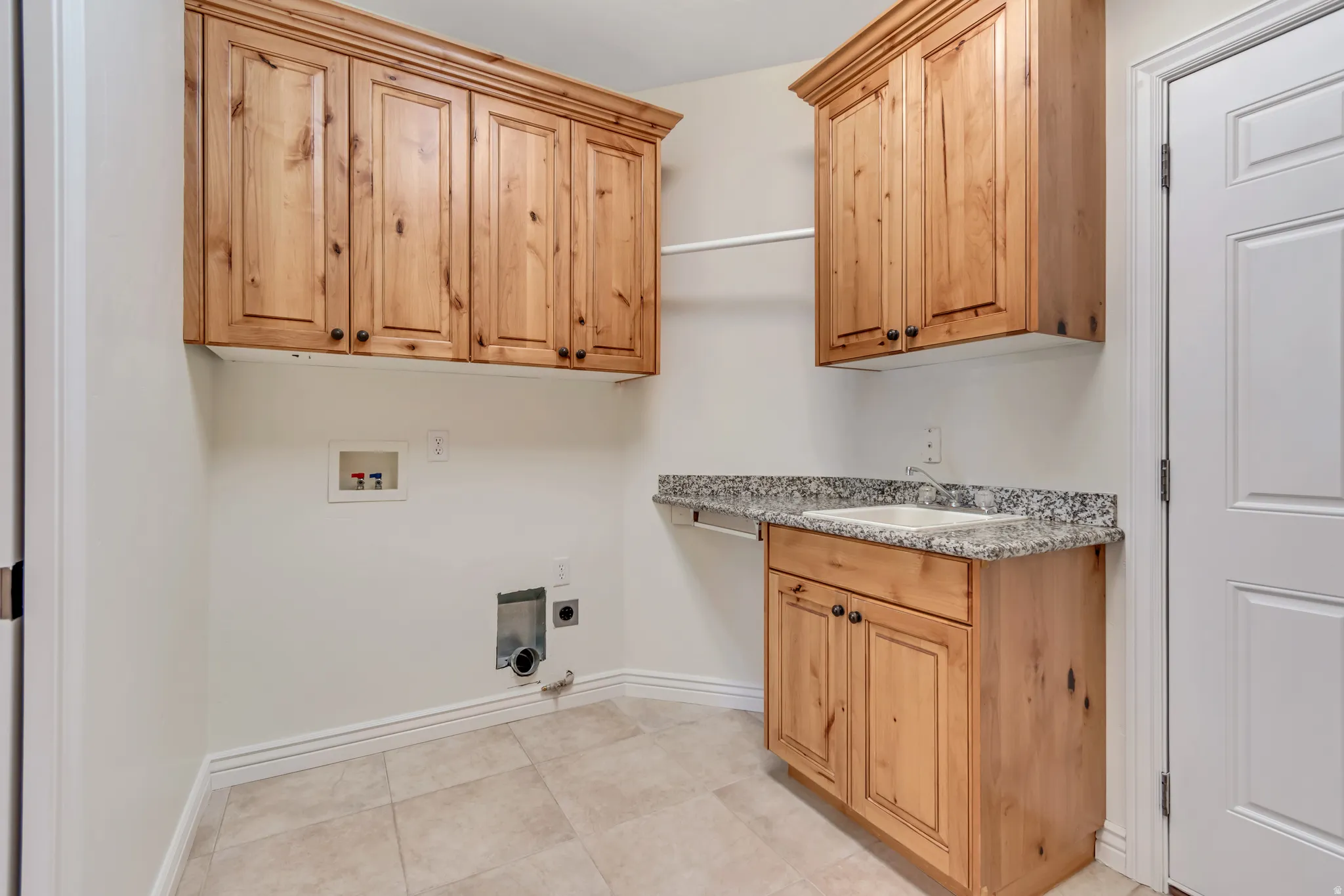 Laundry area featuring washer hookup, cabinet space, hookup for an electric dryer, and light tile patterned flooring