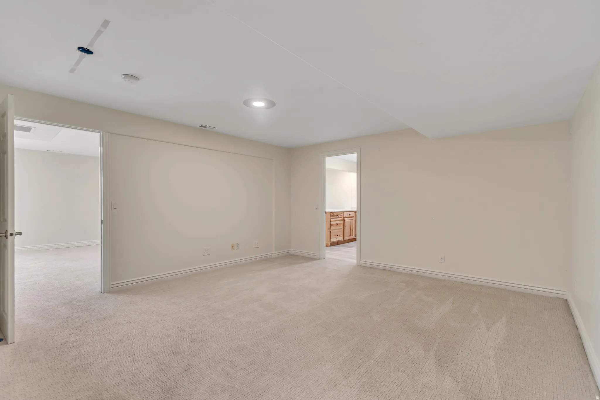Spare room featuring light colored carpet and recessed lighting