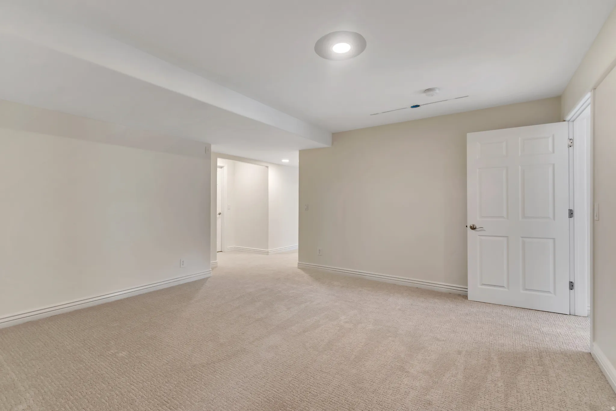 Spare room featuring light colored carpet and baseboards
