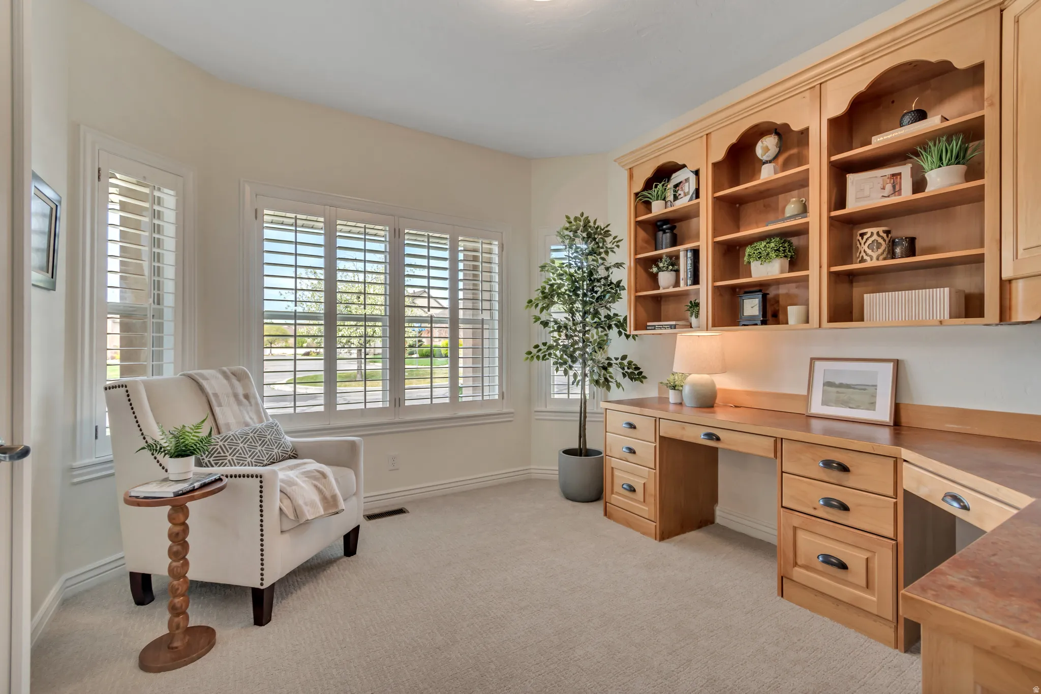 Office space featuring light carpet and built in study area