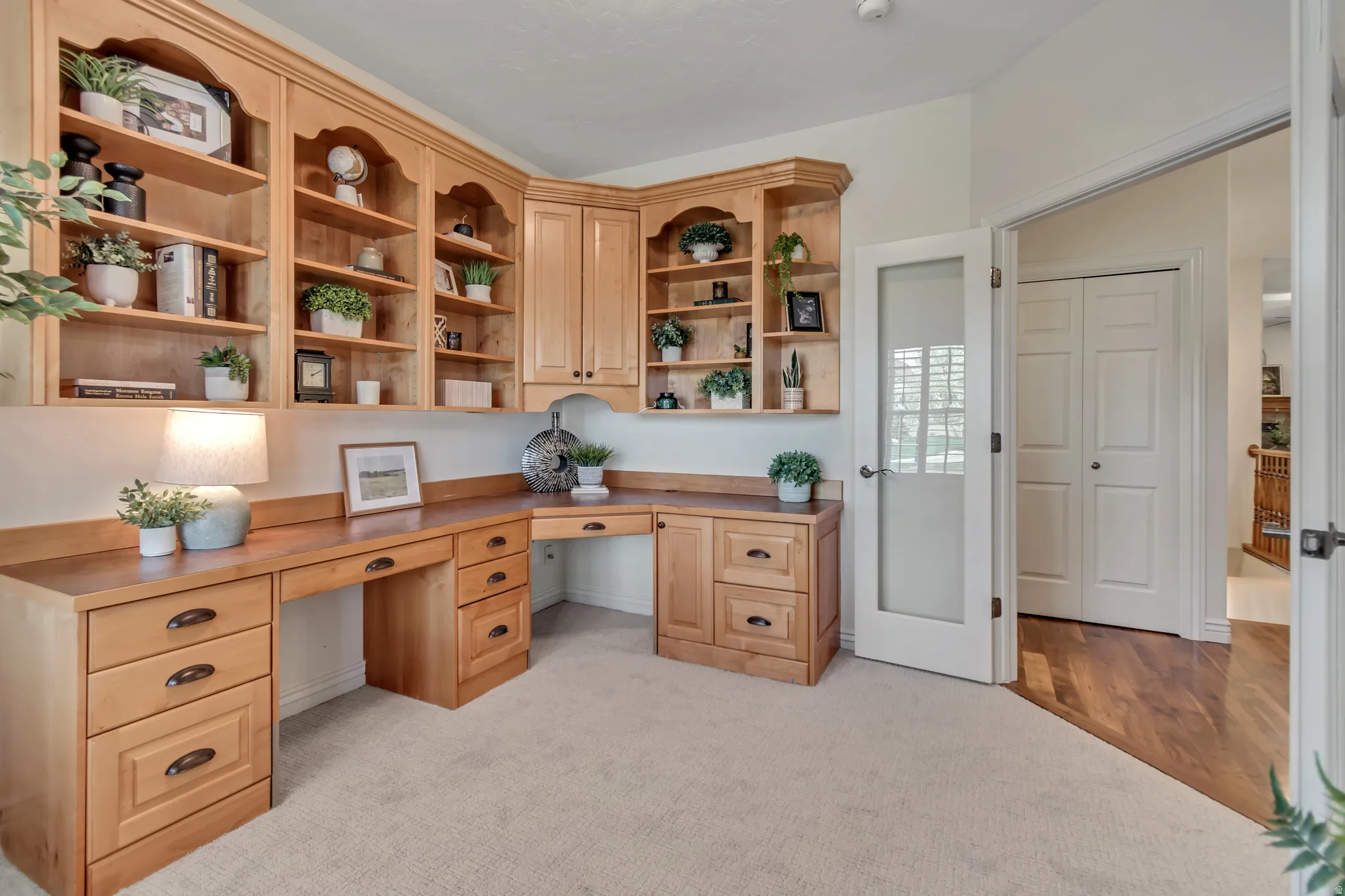 Office area featuring built in desk and light carpet