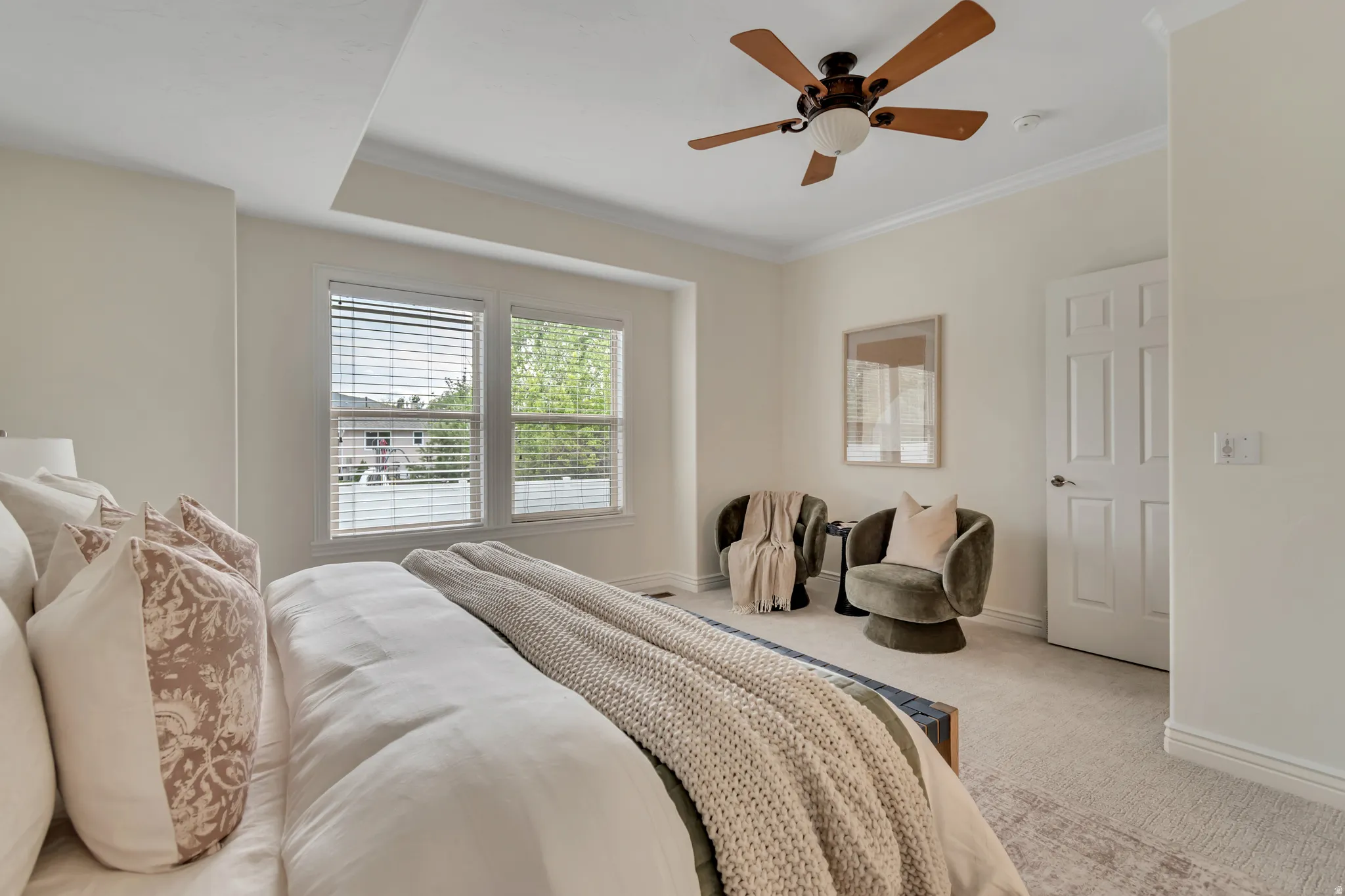 Bedroom featuring light carpet, crown molding, and ceiling fan