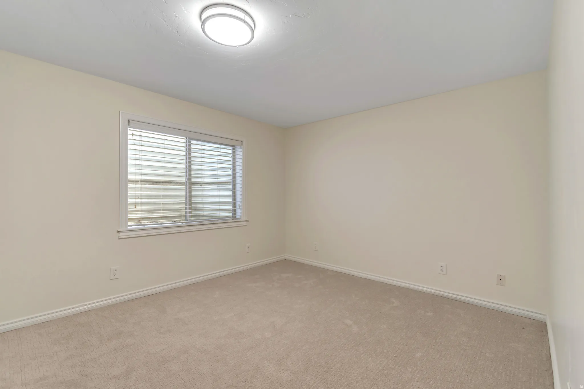 Carpeted spare room with baseboards
