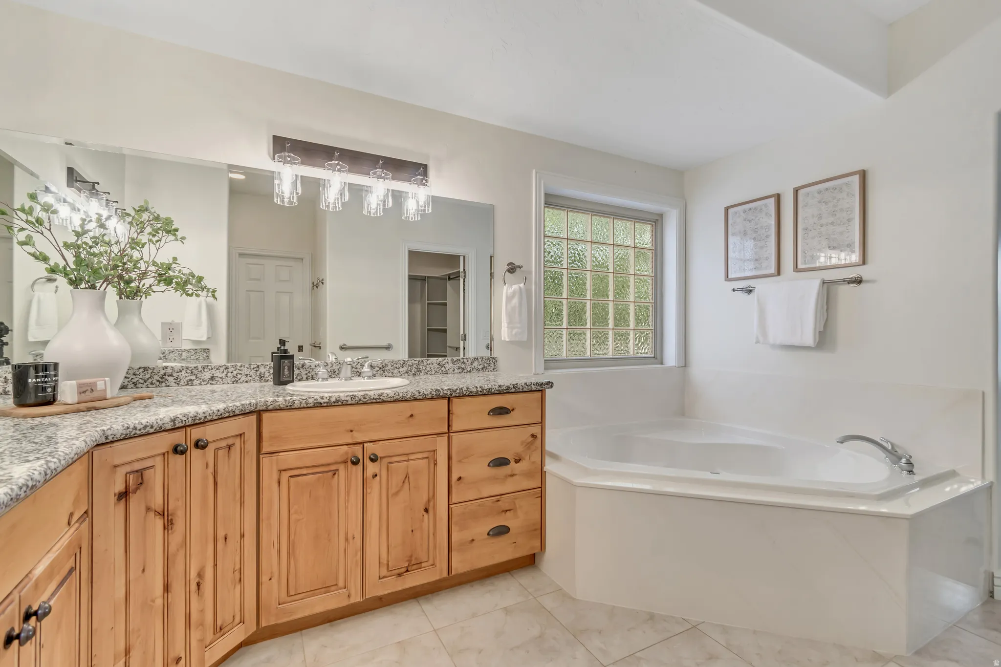 Full bath with vanity, a bath, and light tile patterned floors