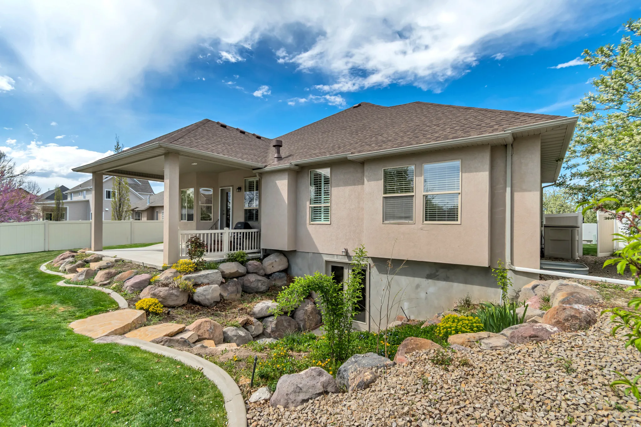 Rear view of property with stucco siding, a patio, and a shingled roof