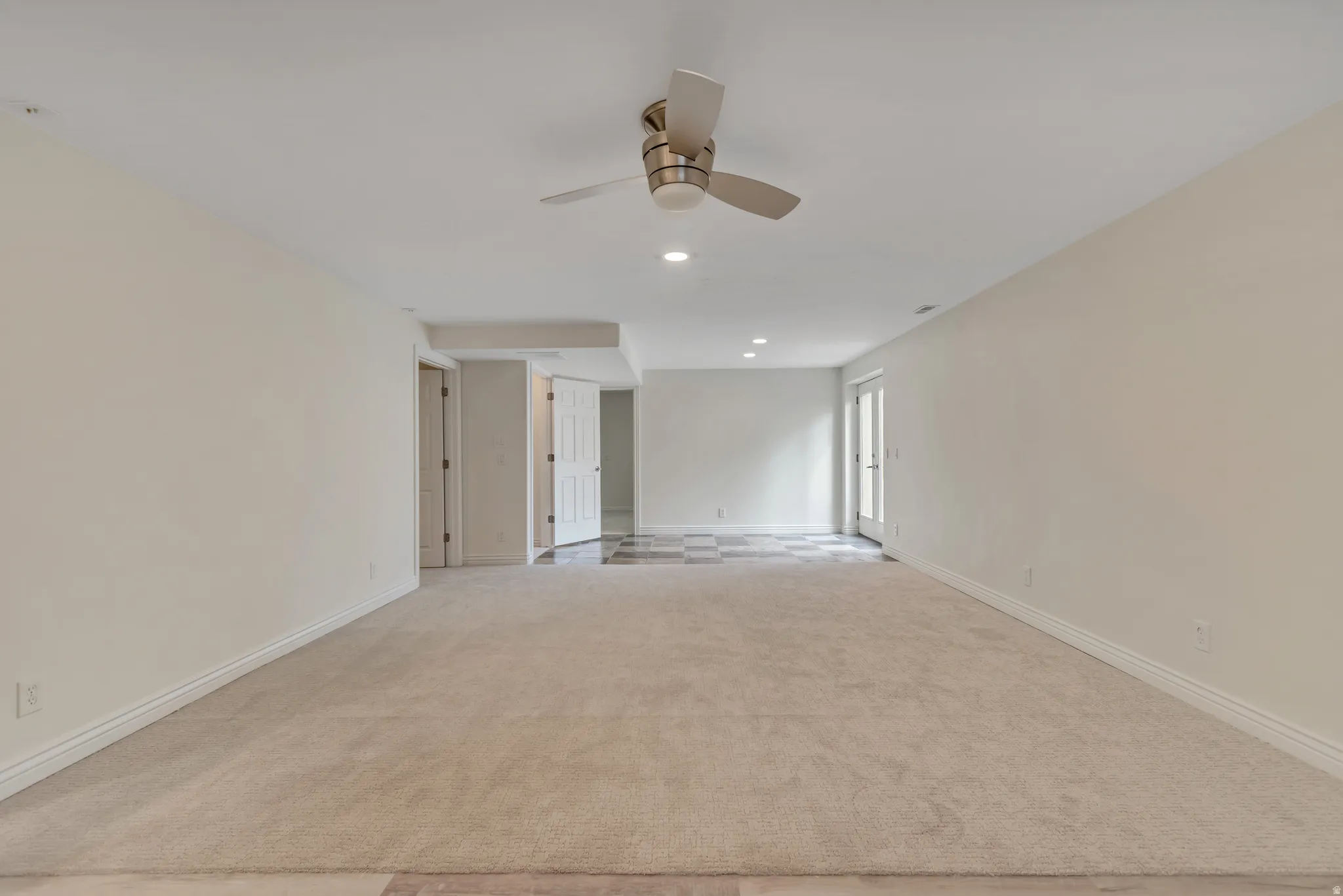 Spare room with a ceiling fan, light carpet, and recessed lighting