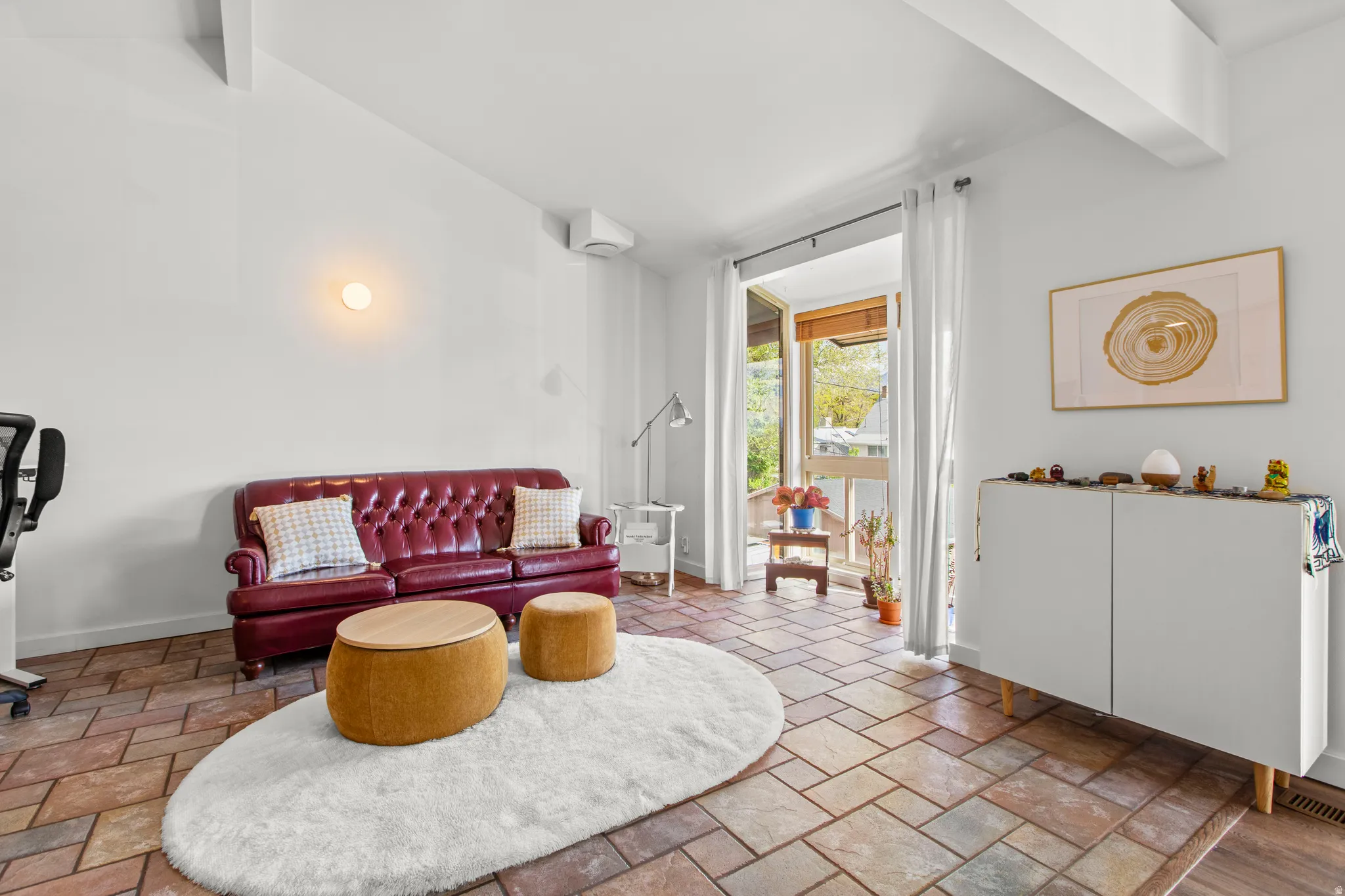 Living area with vaulted ceiling with beams and stone tile floors
