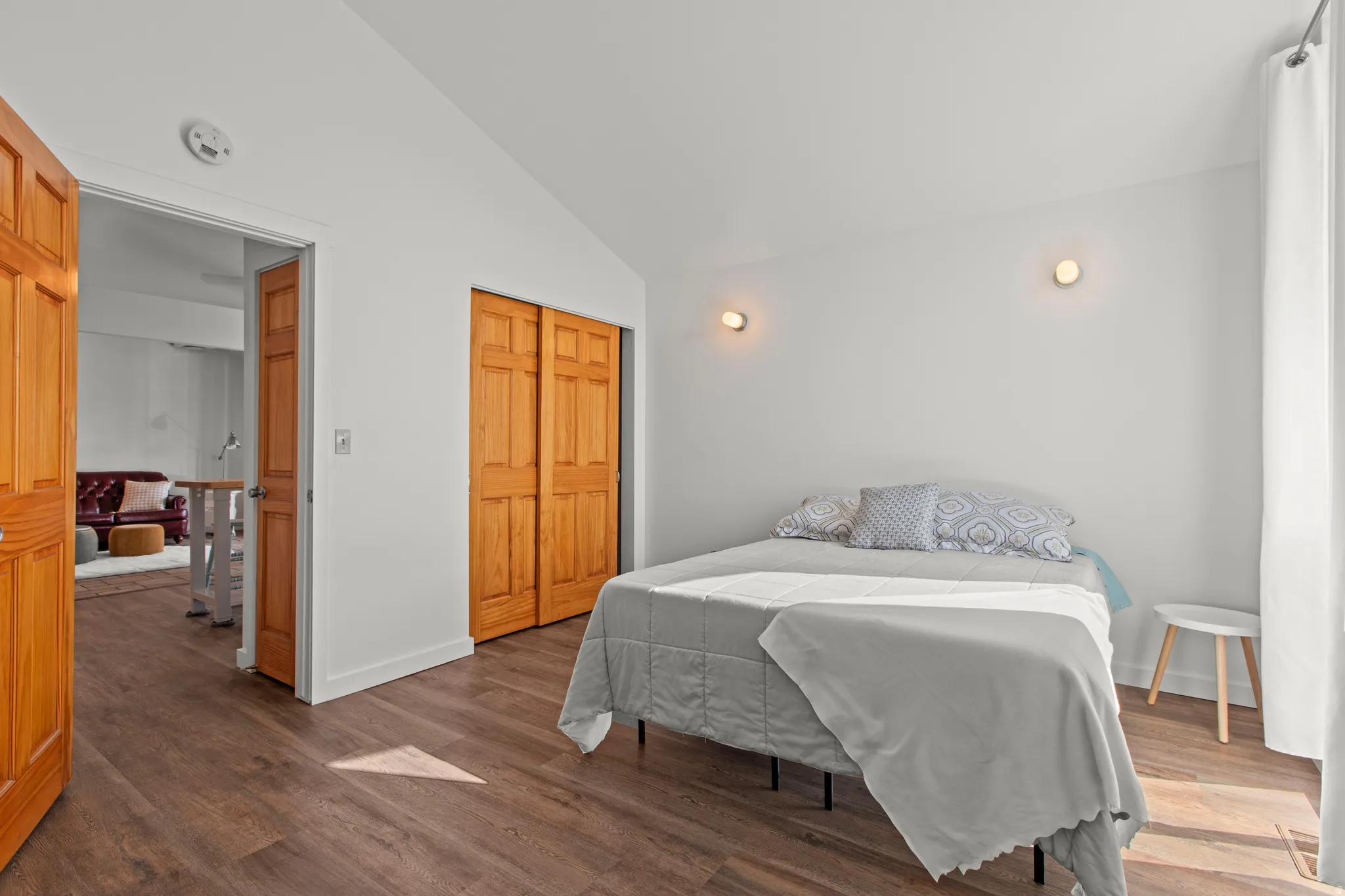Bedroom with lofted ceiling, large windows, and LVP floors
