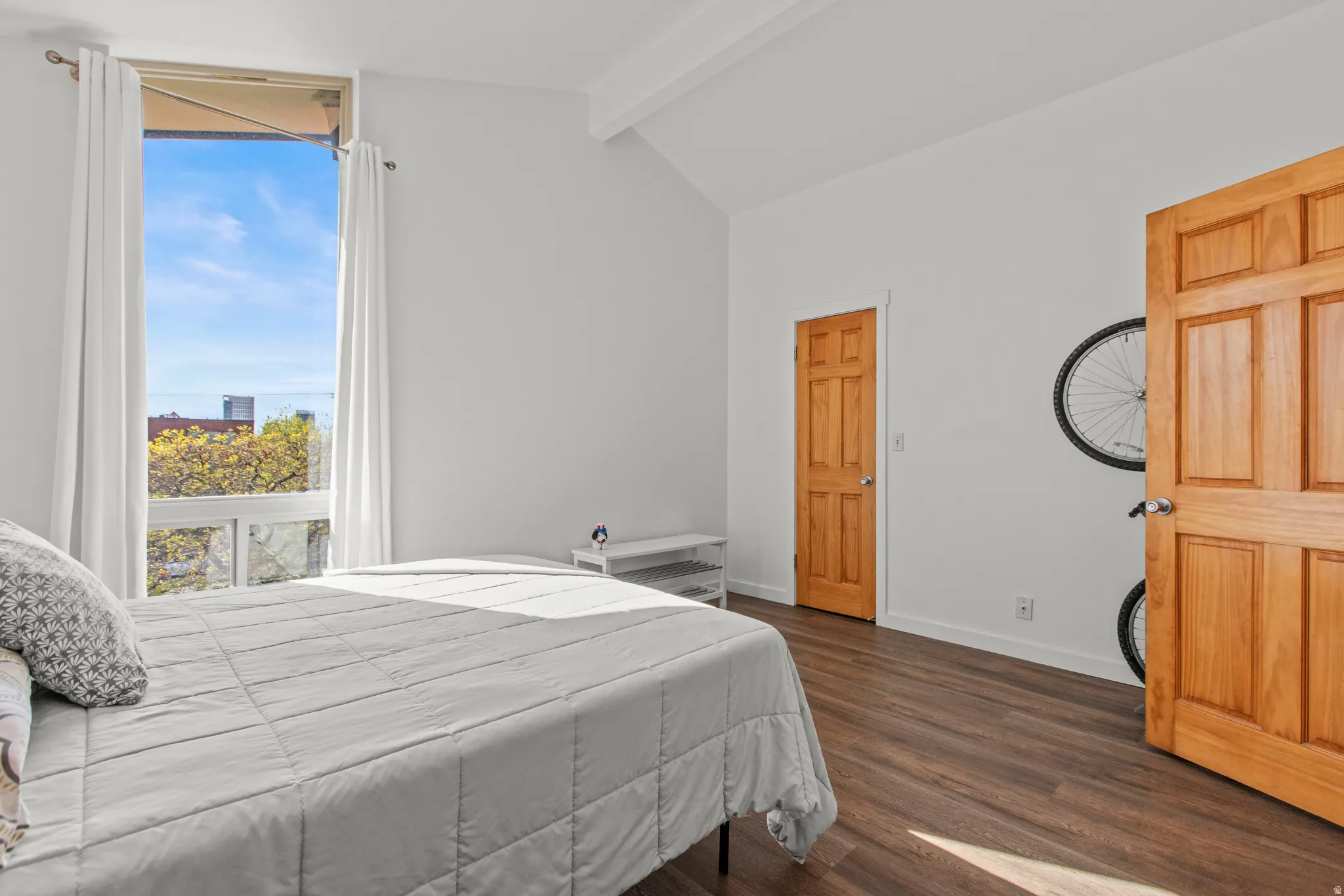 Bedroom with lofted ceiling, large windows, and LVP floors