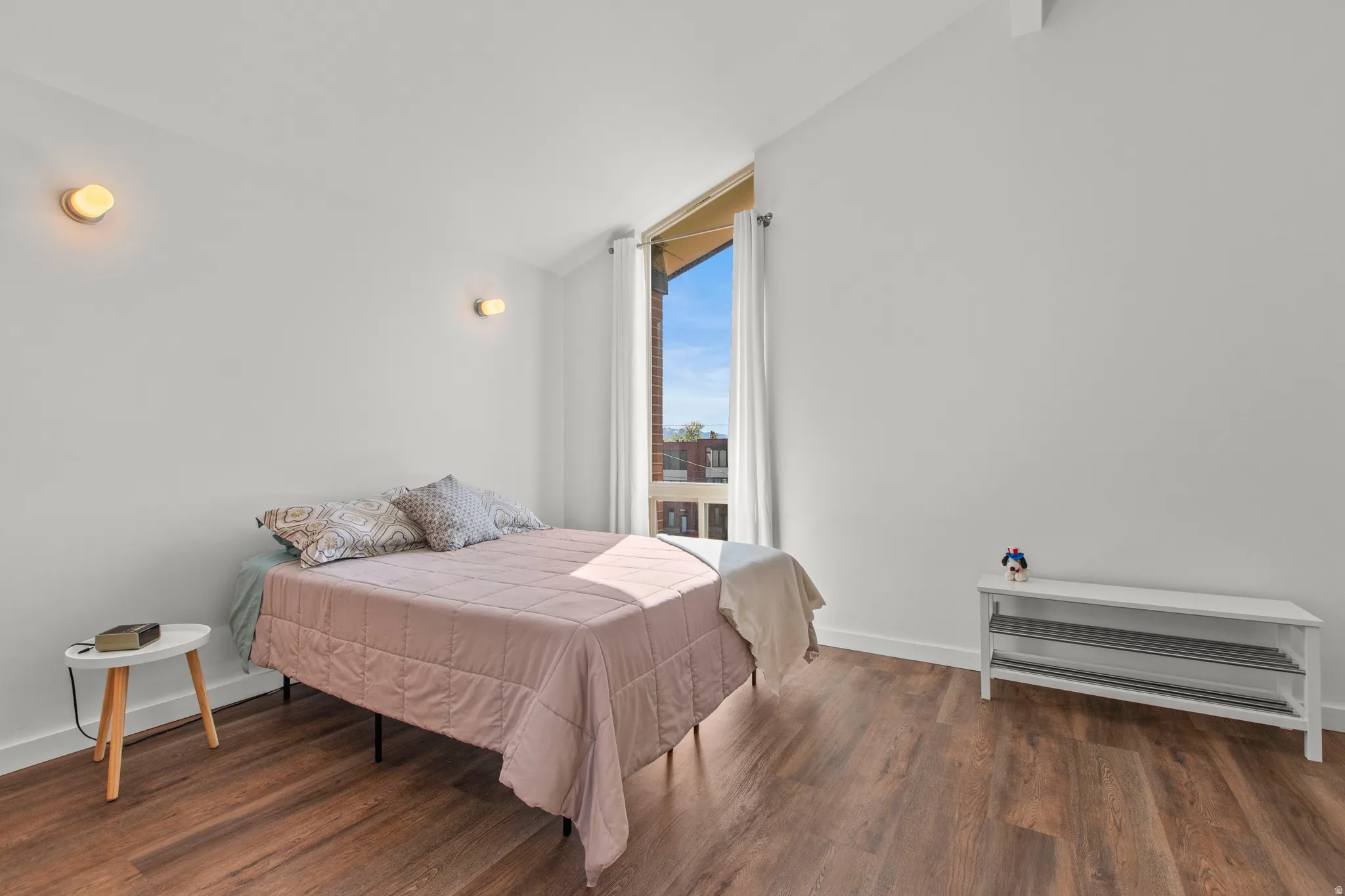 Bedroom with lofted ceiling, large windows, and LVP floors