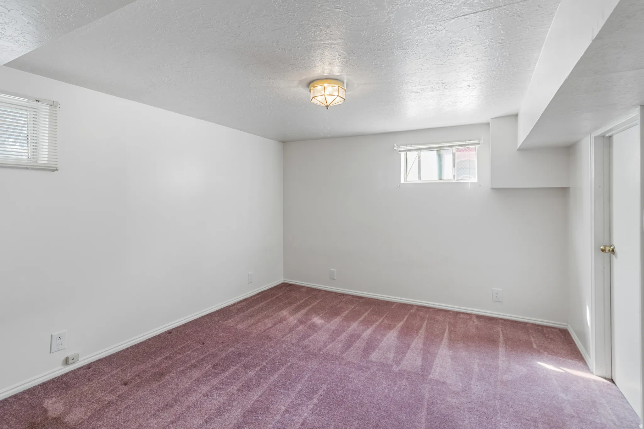 Below grade area featuring carpet floors and a textured ceiling