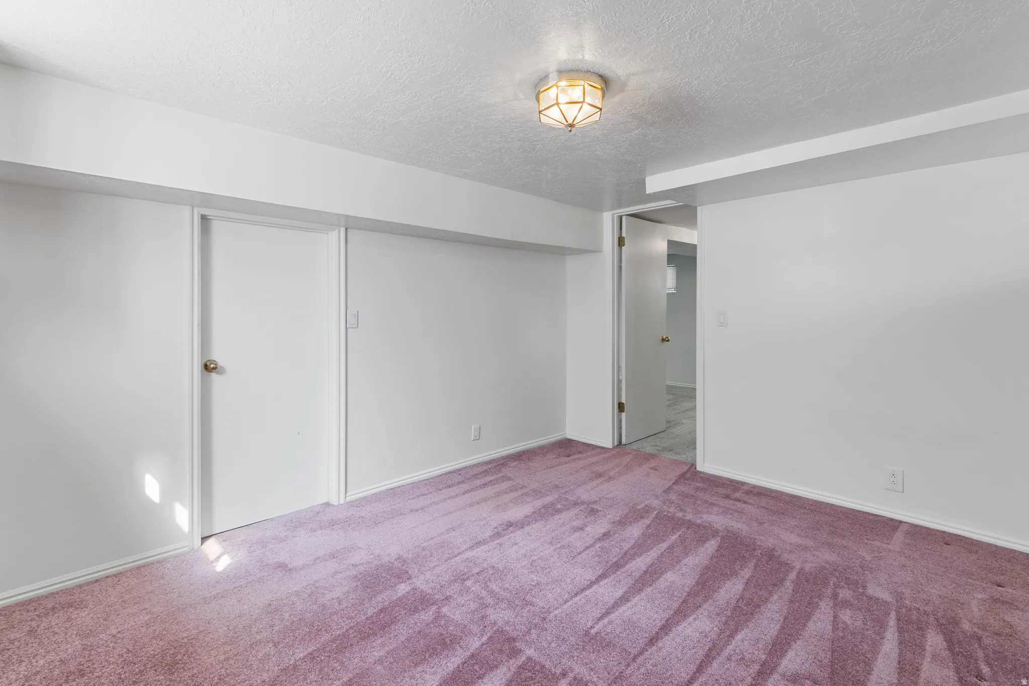 Finished below grade area with a textured ceiling and carpet floors