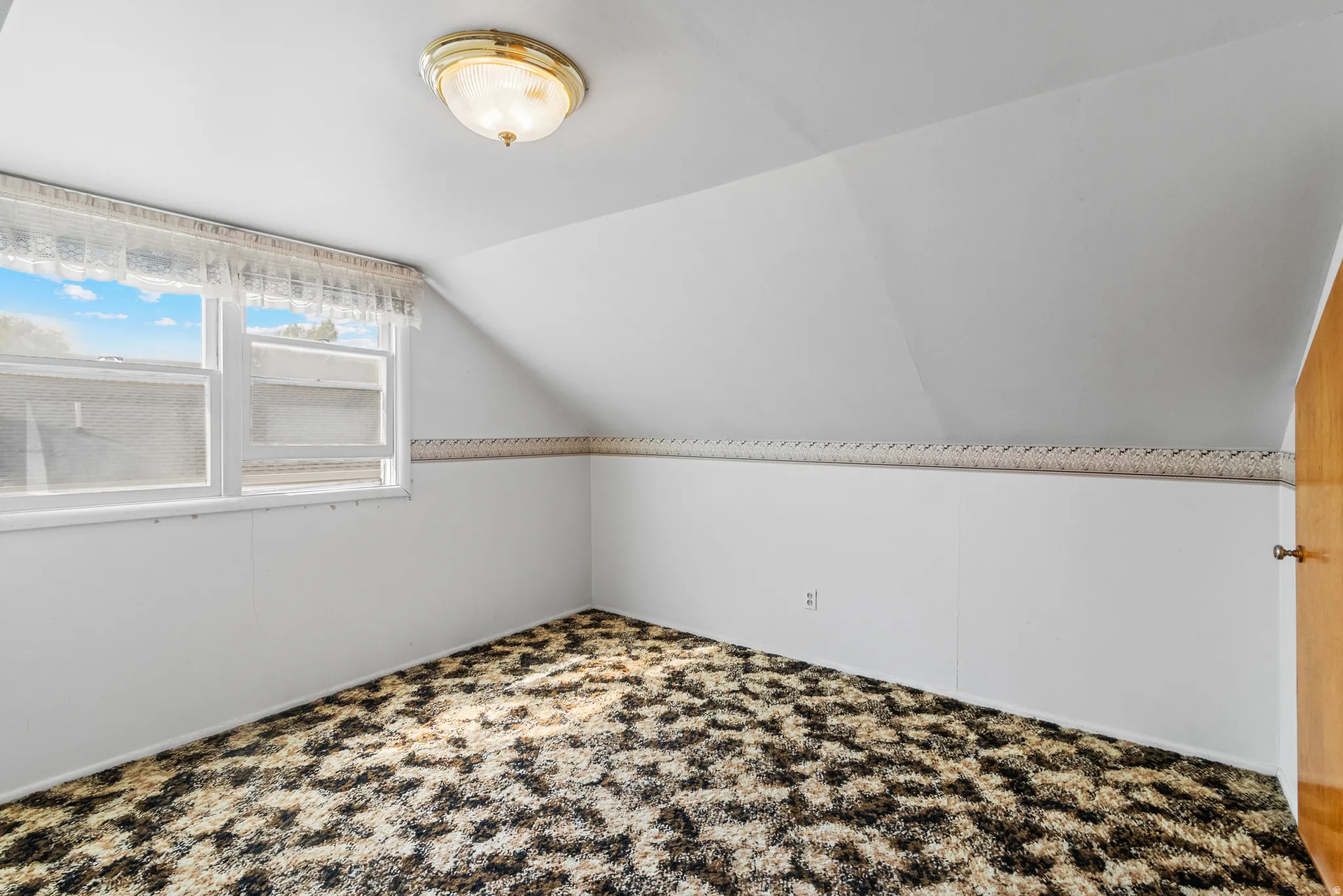 Bonus room with lofted ceiling and carpet flooring
