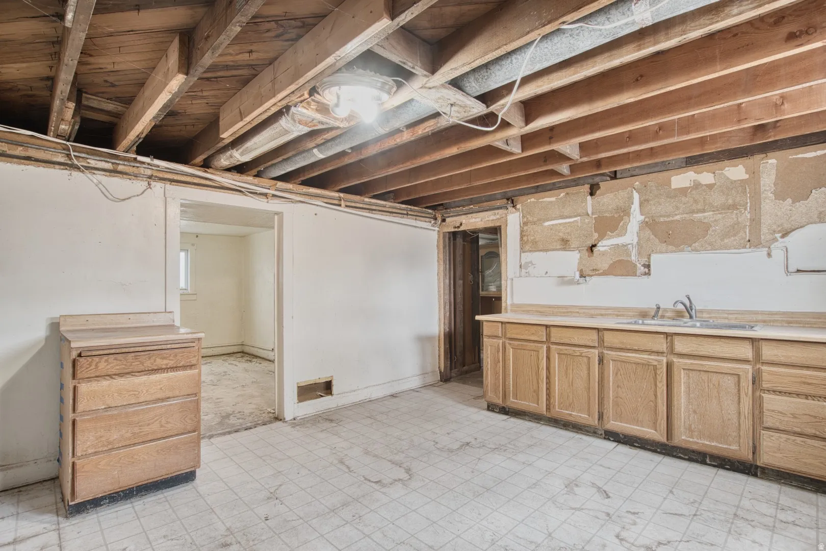 Basement featuring light floors and a sink
