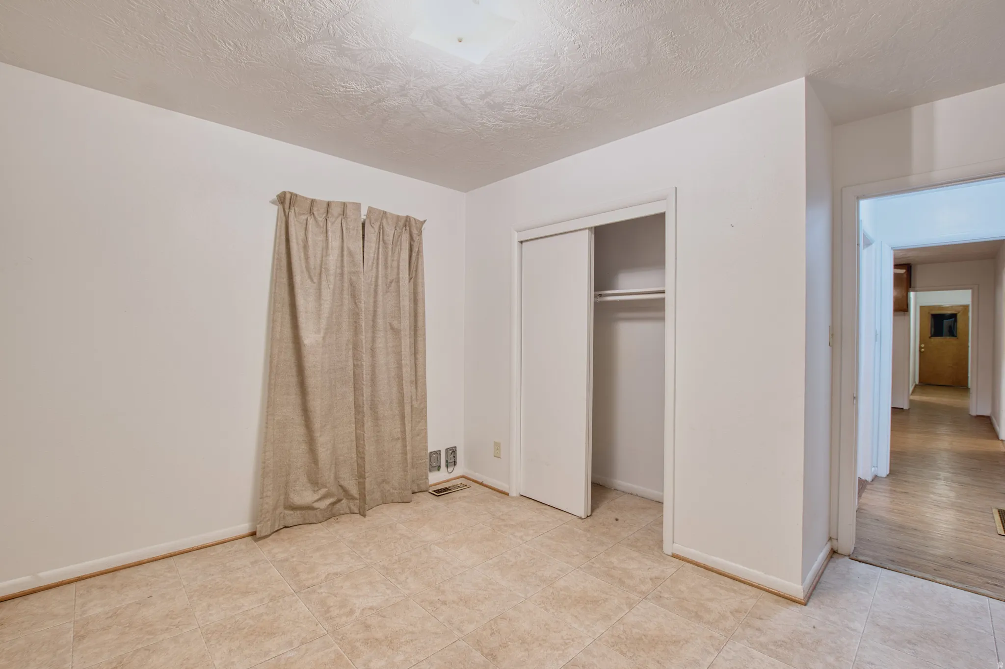 Unfurnished bedroom with a textured ceiling and a closet