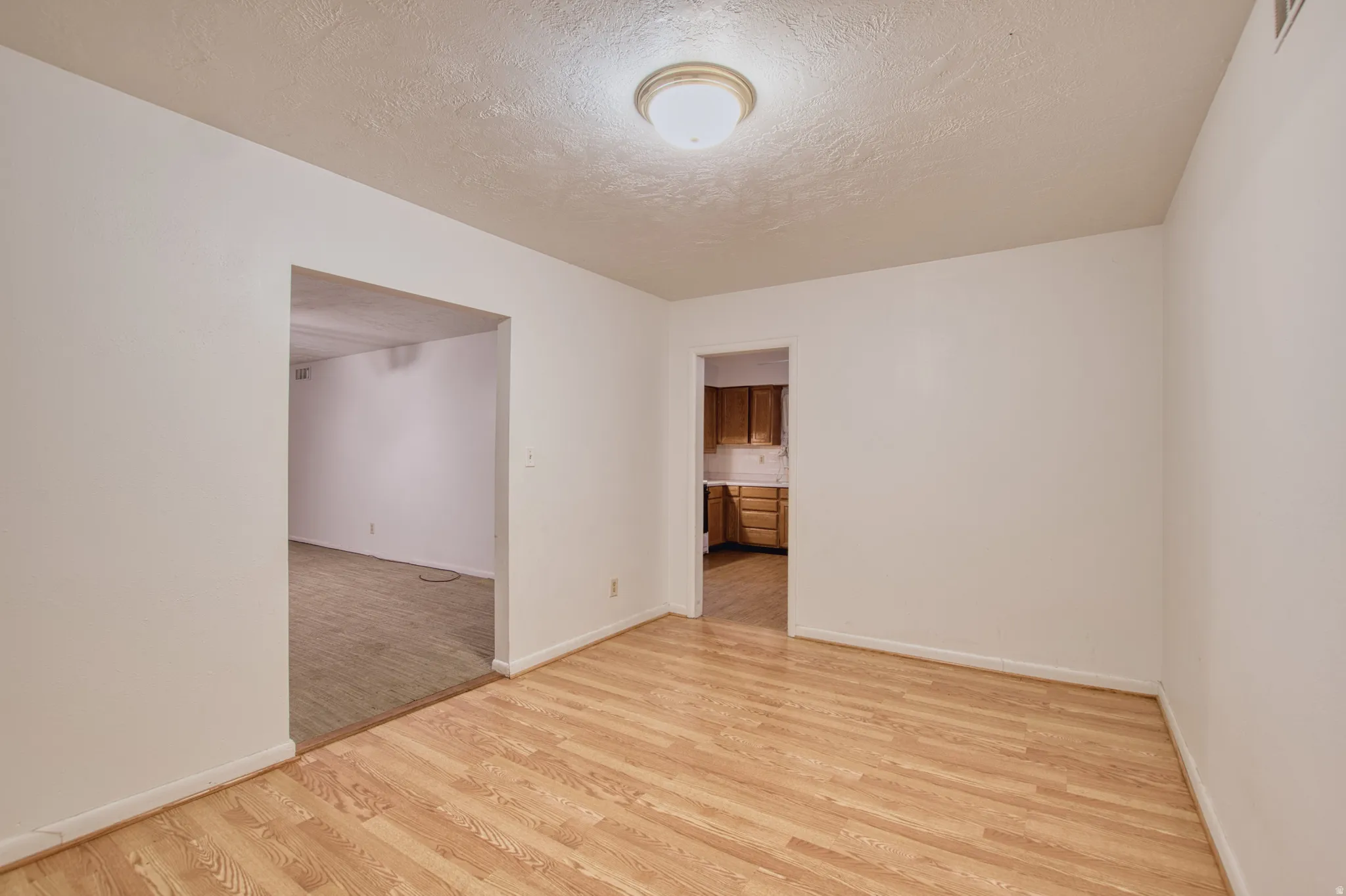 Dining room featuring light wood-style floors and a textured ceiling