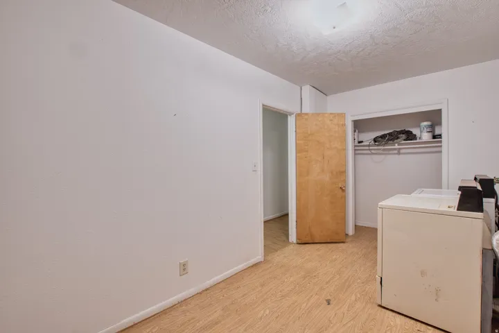 Laundry area featuring light wood-style floors, a textured ceiling, and independent washer and dryer