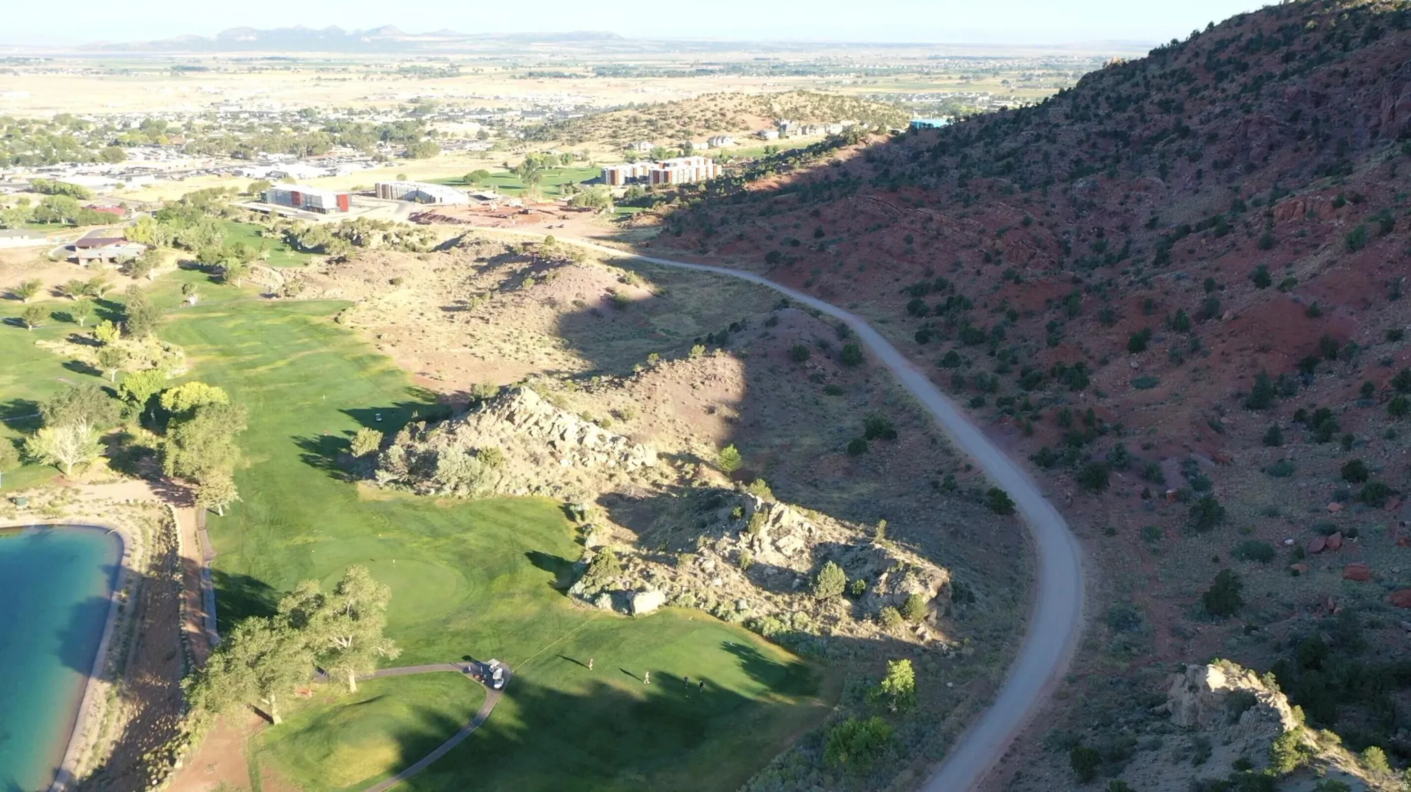 Aerial view of property and surrounding area with a mountain backdrop and a golf course