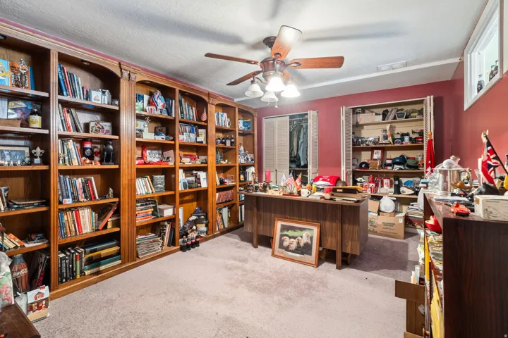 Office area featuring light colored carpet, a ceiling fan, and a textured ceiling