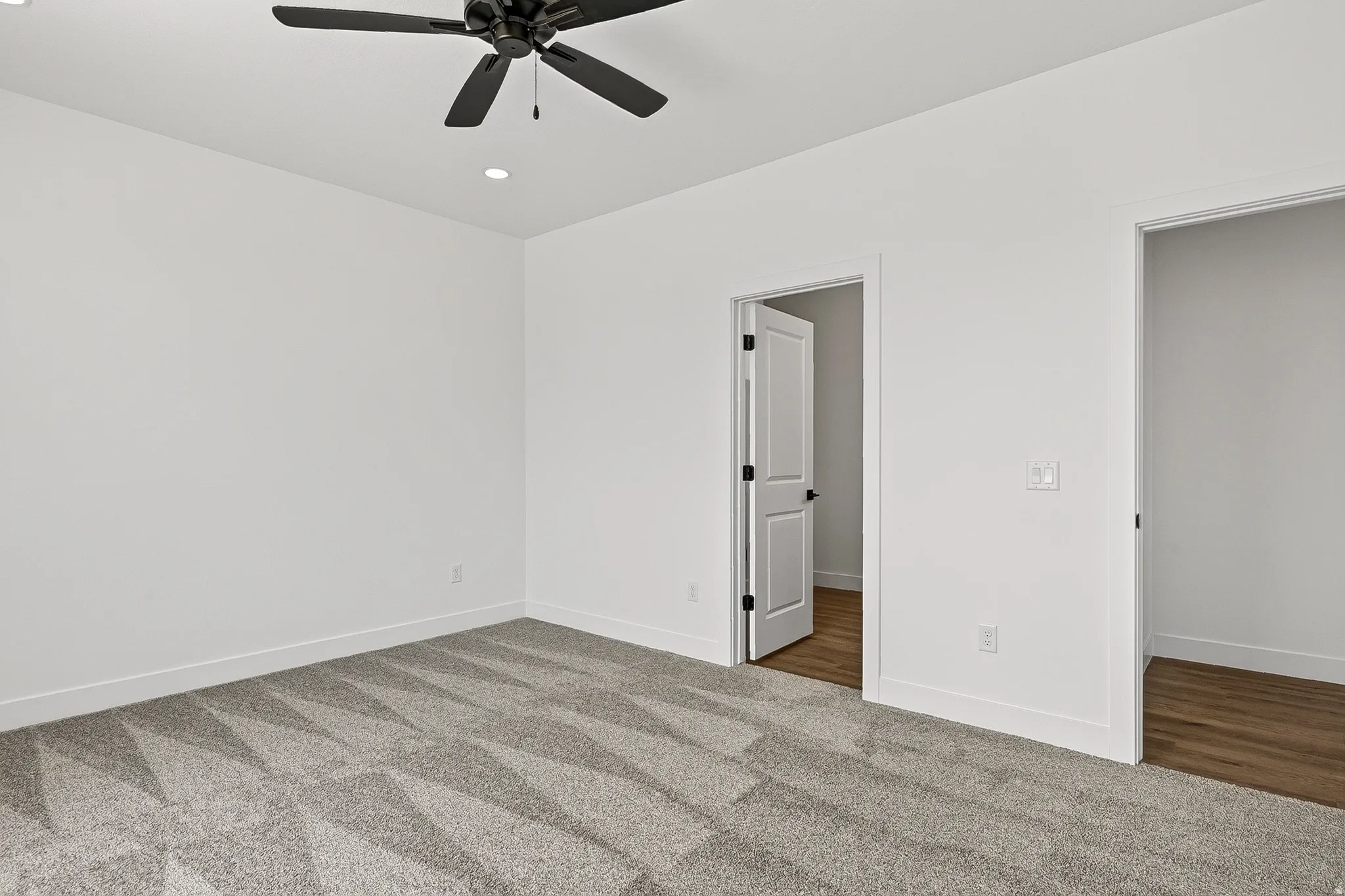 Room featuring patterned carpet flooring, recessed lighting, and a ceiling fan with matte black blades