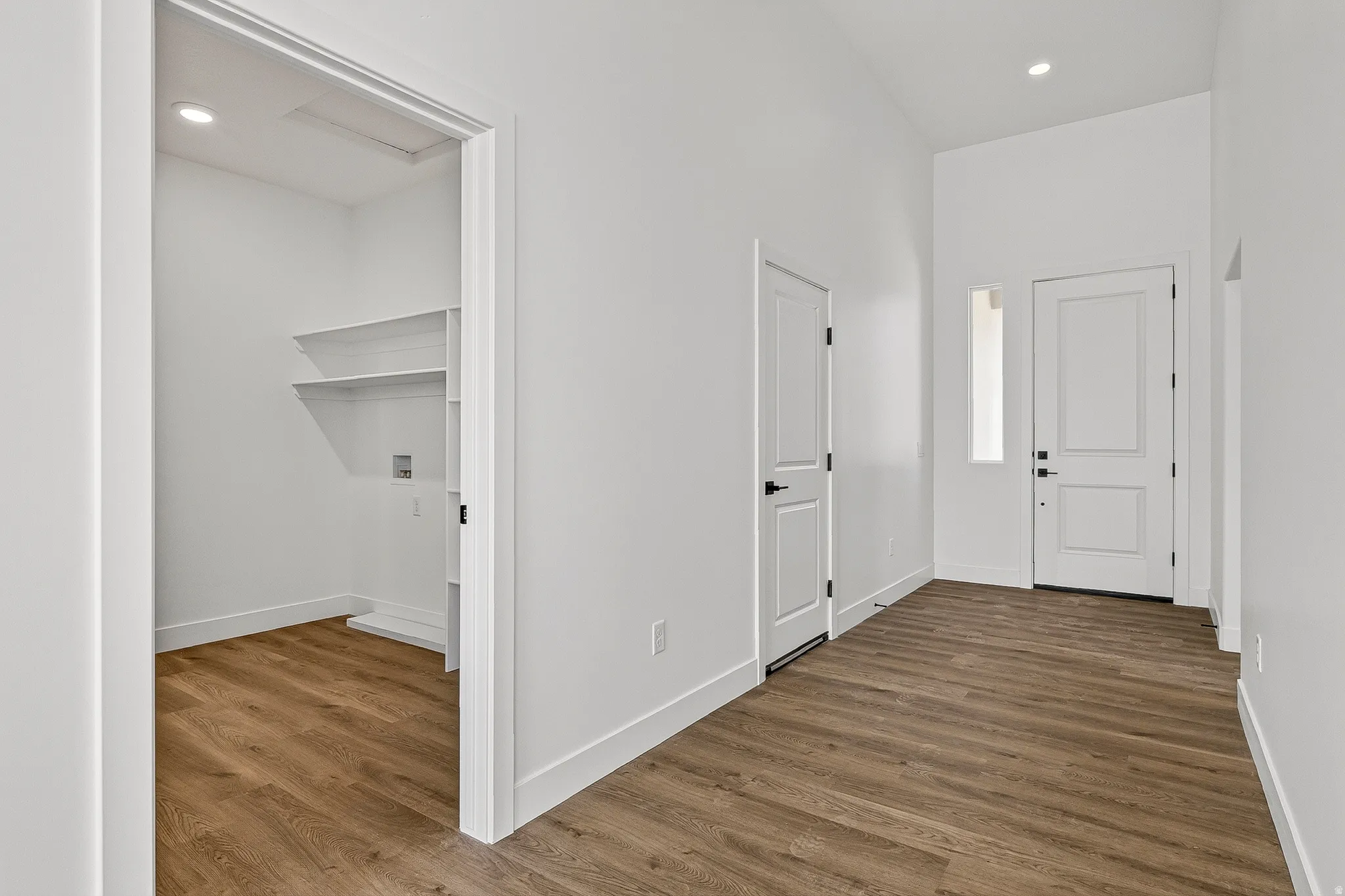 Entryway featuring wood-finish flooring, a white paneled entry door with sidelight, and recessed lighting