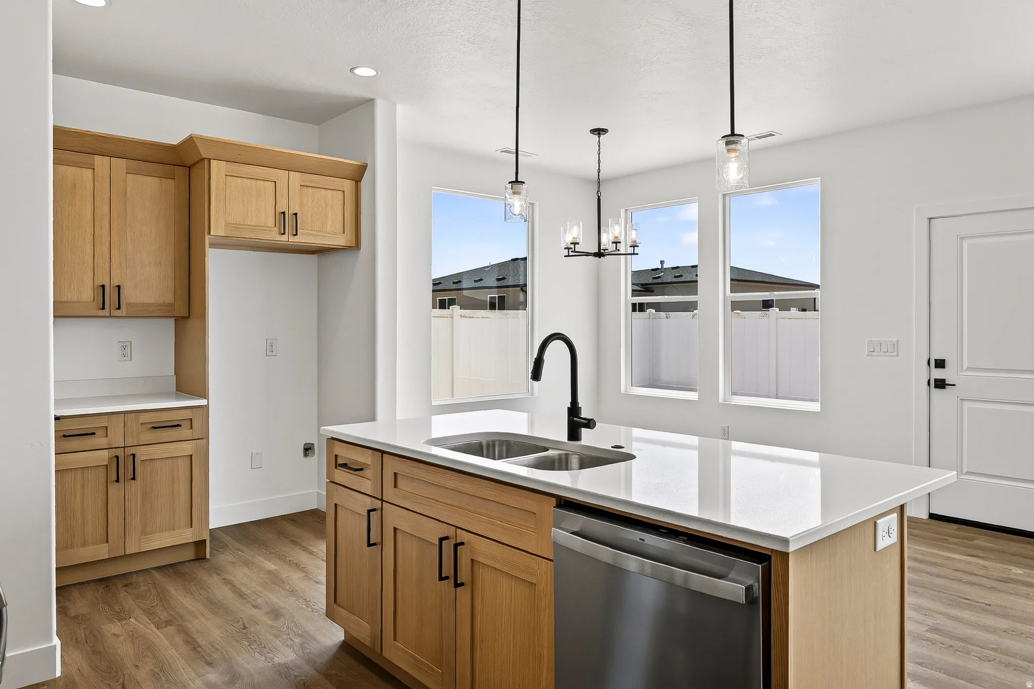 Kitchen featuring an island with a dual basin sink and stainless steel dishwasher
