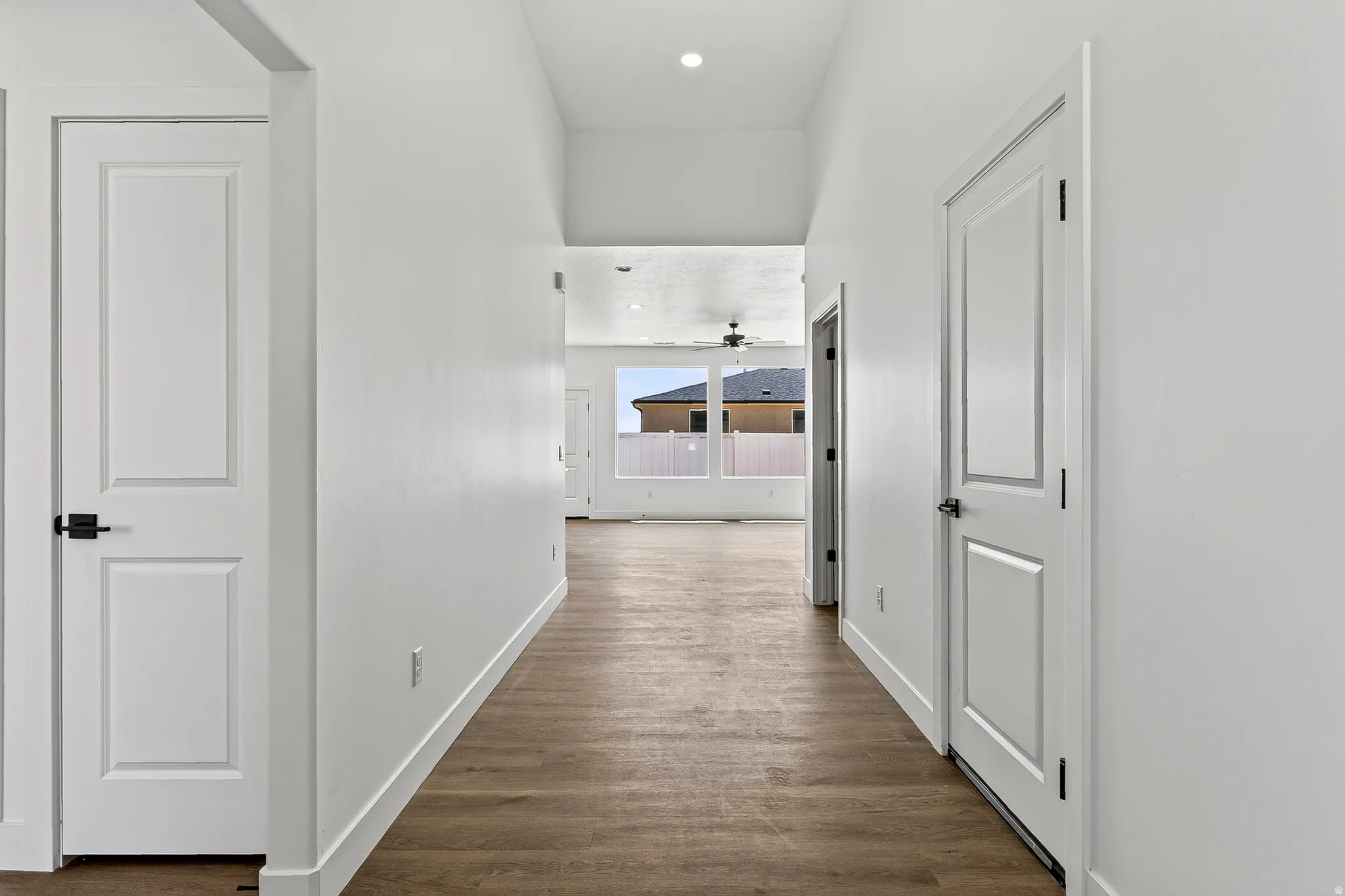 Hallway featuring wood-finish flooring and bright white walls