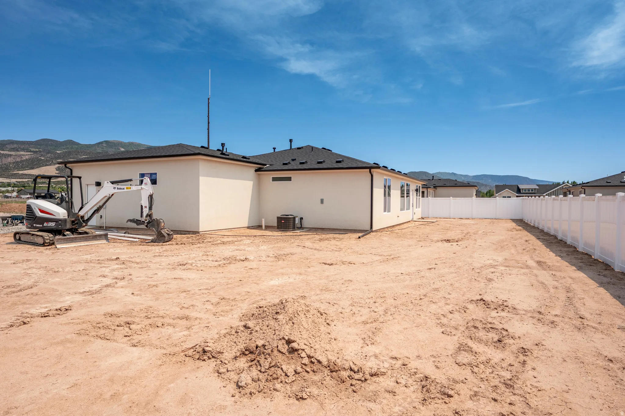 Expansive rear yard with a newly installed white privacy fence