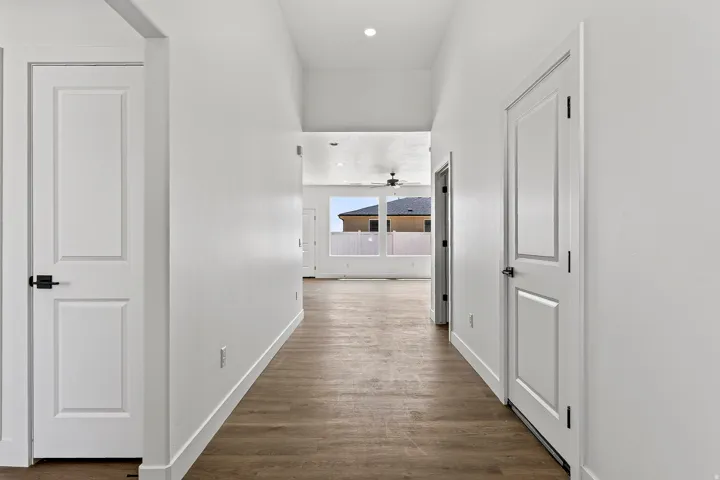 Hallway featuring wood-finish flooring and bright white walls