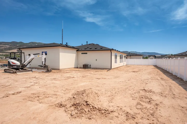 Expansive rear yard with a newly installed white privacy fence