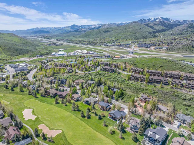 Aerial view of property and surrounding area with a mountainous background and nearby suburban area