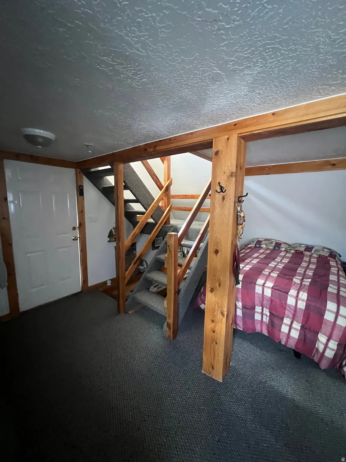 Bedroom #1 featuring a textured ceiling and carpet floors