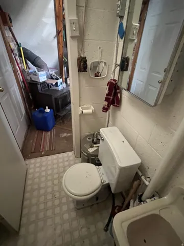 Half bath with toilet and light floors