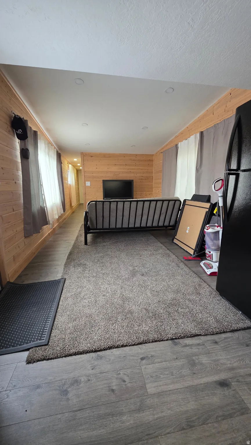 Miscellaneous room with wooden walls and dark wood-type flooring