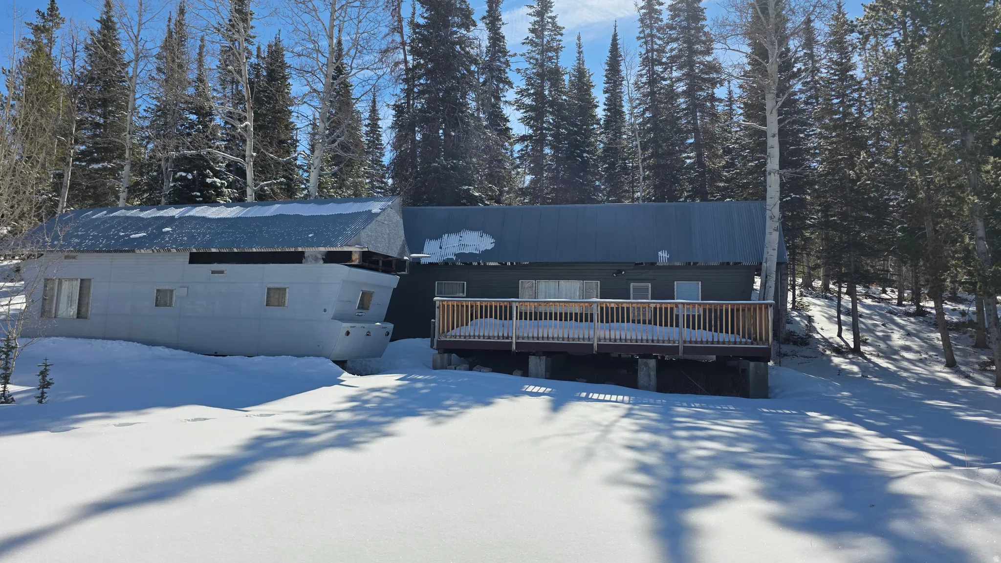 Snow covered house with a wooden deck