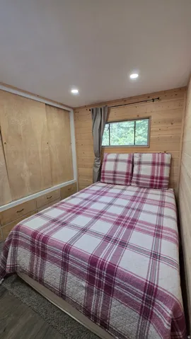 Interior space featuring wood-finish wall paneling, a built-in storage unit with drawers, and a window with a natural outdoor backdrop