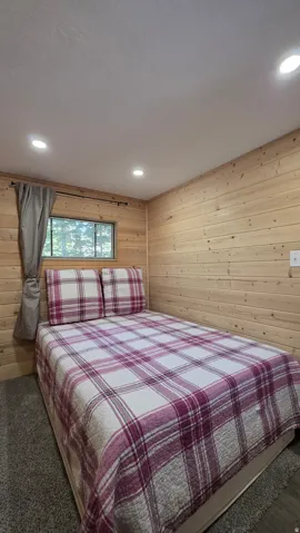 Bedroom featuring horizontal wood paneling, recessed lighting, a window with exterior views, and gray carpet flooring