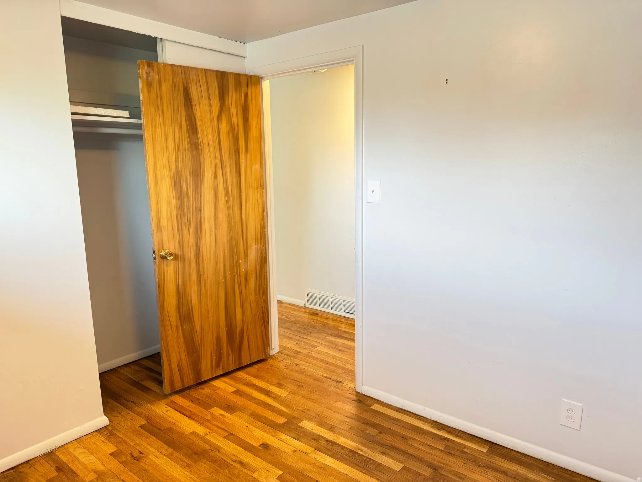 Unfurnished bedroom featuring a closet and light wood-style floors