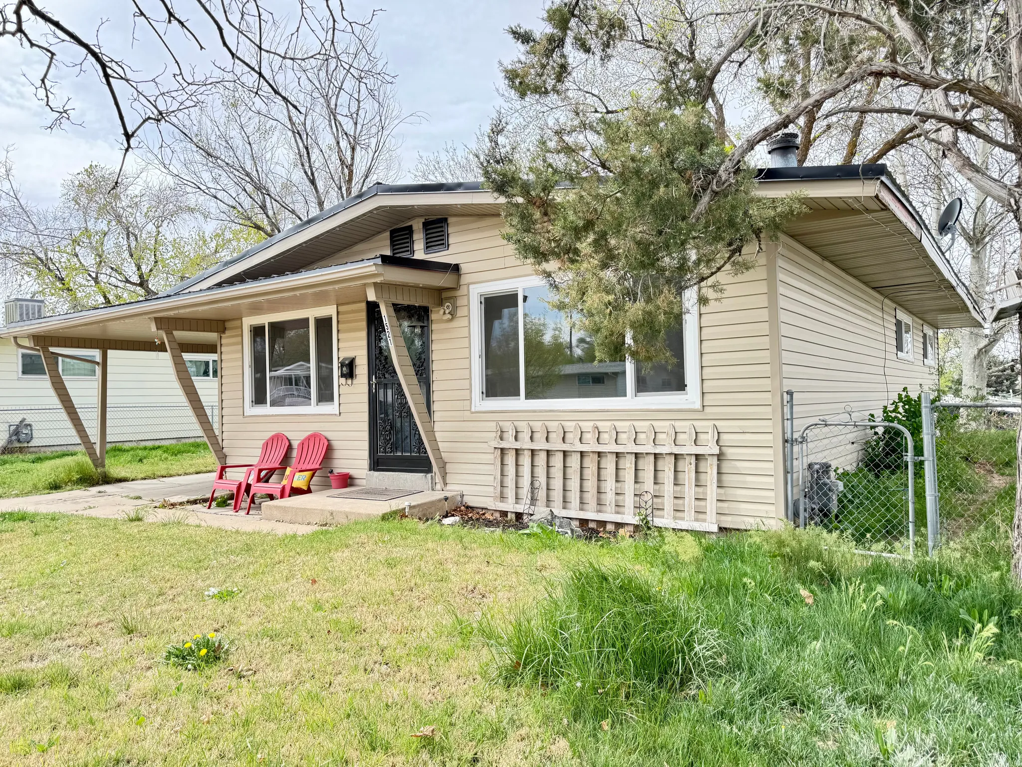 View of front facade featuring an attached carport, covered porch, and a gate