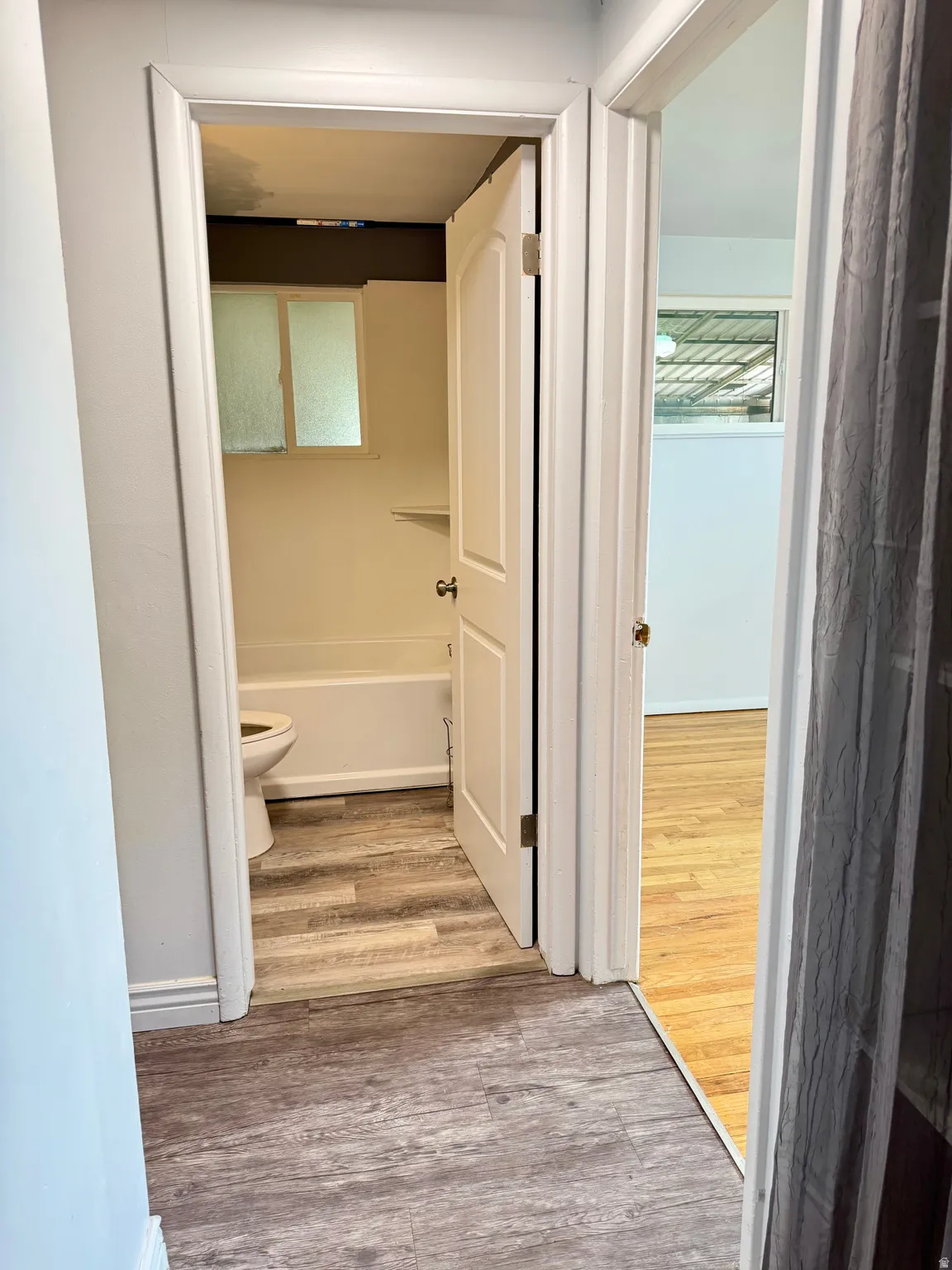 Bathroom featuring light wood-style flooring and a bathtub