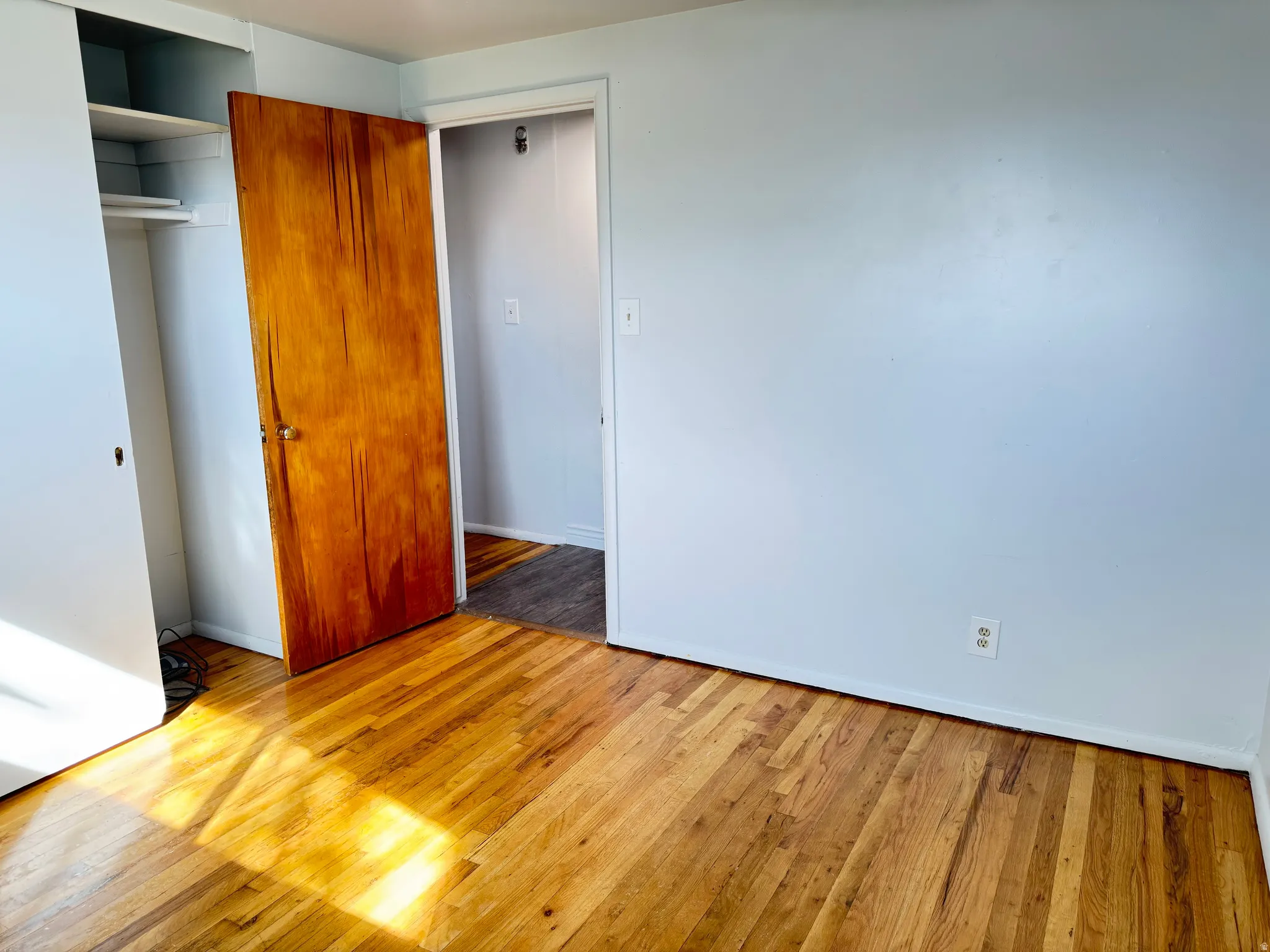 Unfurnished bedroom with light wood-type flooring and a closet