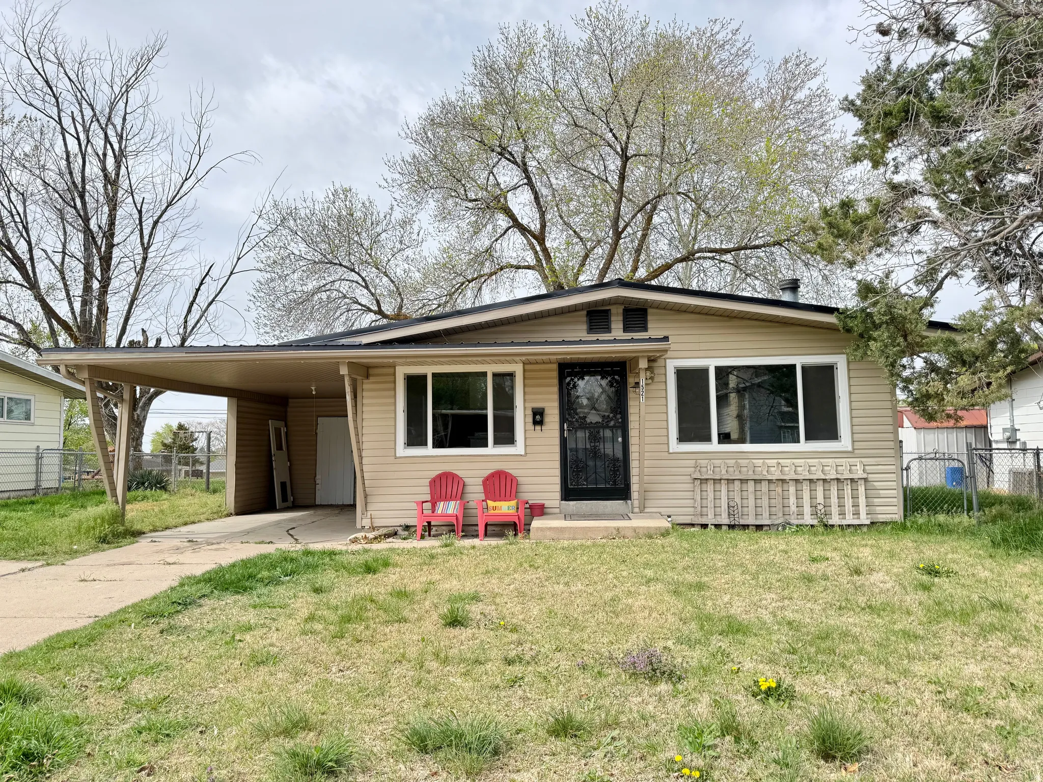 View of front of home featuring an attached carport and concrete driveway