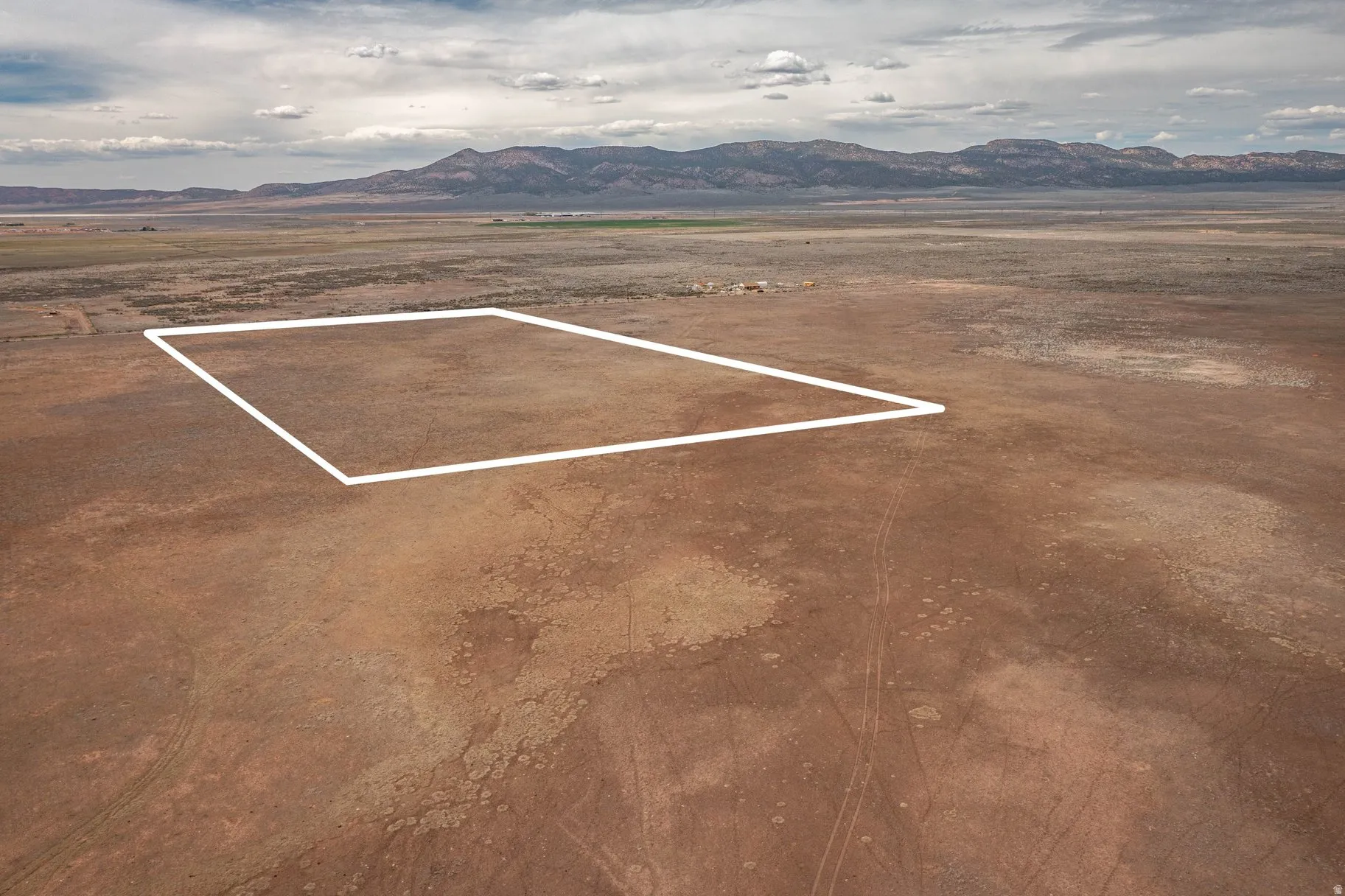 Aerial view of sparsely populated area featuring mountains and property parcel outlined