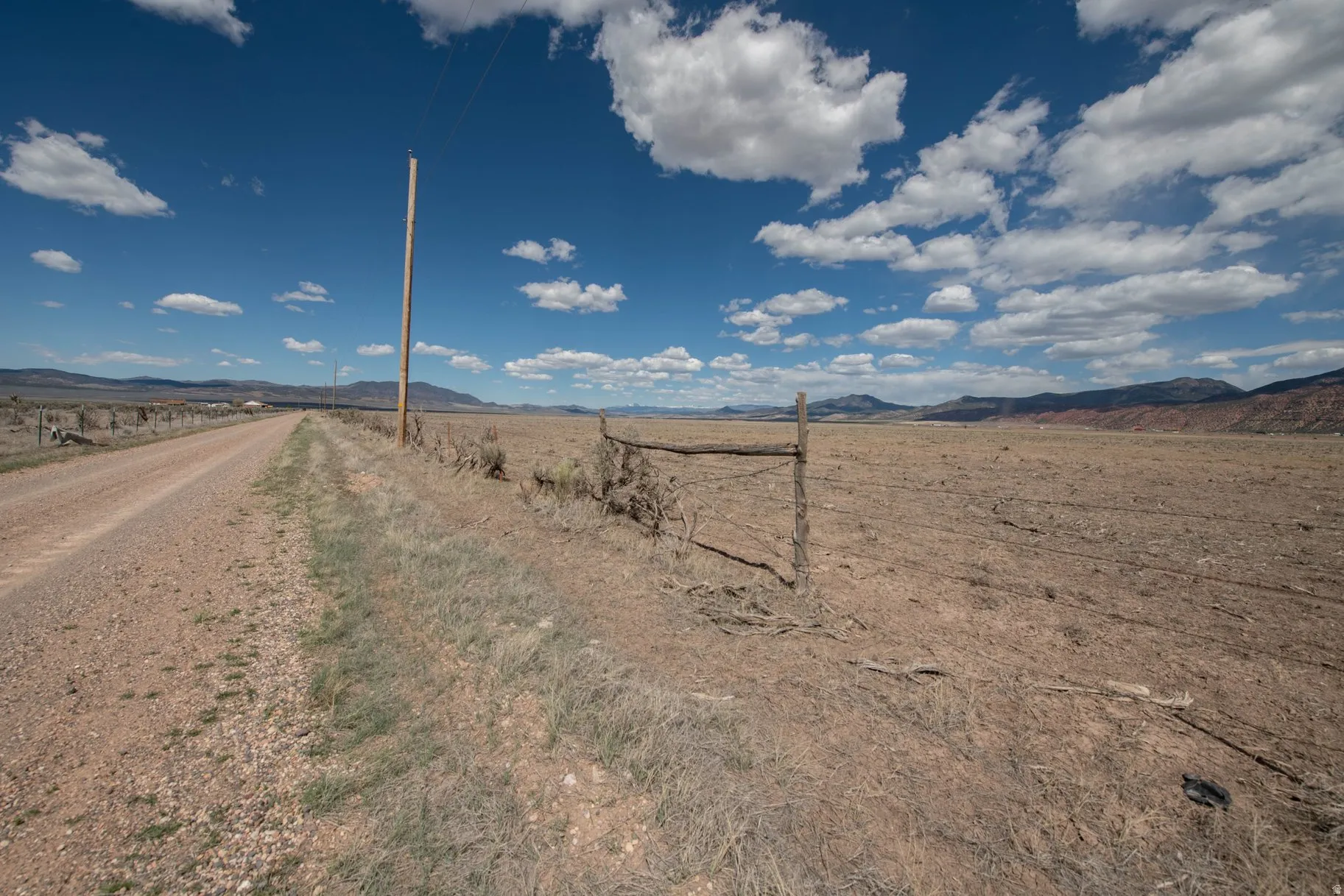 View of dirt / gravel road with a mountain view and a rural view