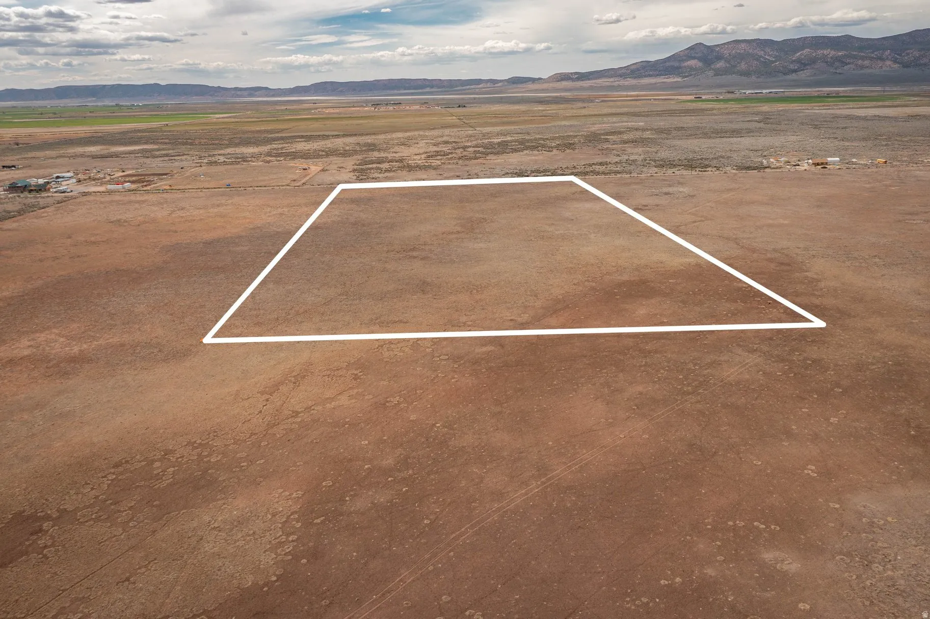 Aerial view of sparsely populated area featuring mountains and property parcel outlined