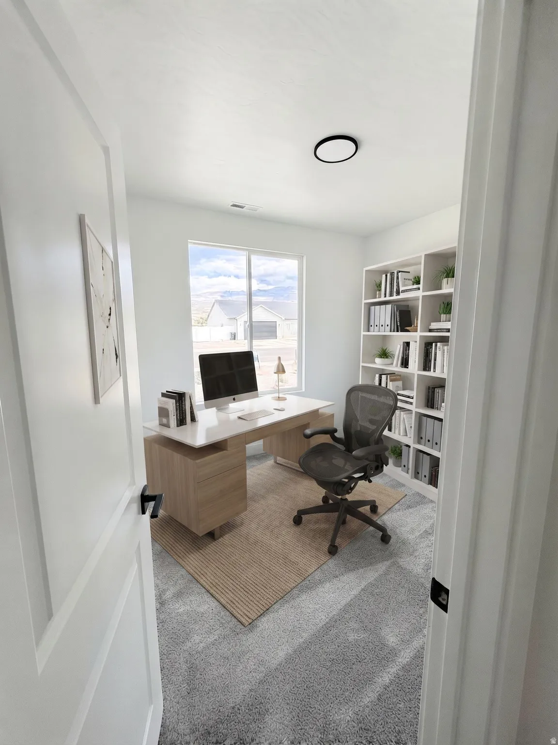 Ai Stage. Neutral-toned carpeting, ample natural light from the large window, and a built-in shelving unit