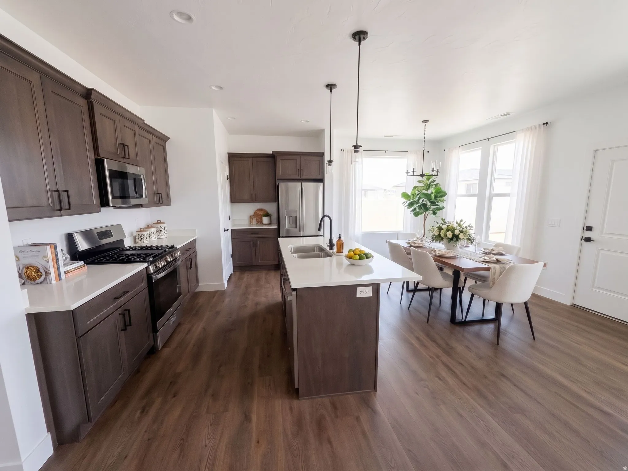 Ai Stage. Spacious open-concept layout featuring wood-finish flooring, white countertops, and dark cabinetry